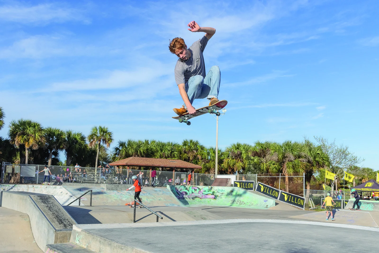 Skater mid-air at Melbourne skate park during a Villon-sponsored event, Brevard County, Florida